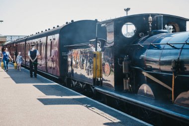 Staff waiting to signal departure of The Poppy Line steam train  clipart