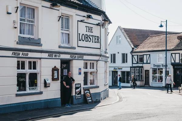 Man si trova all'ingresso del pub The Lobster a Sheringham, Nor — Foto Stock