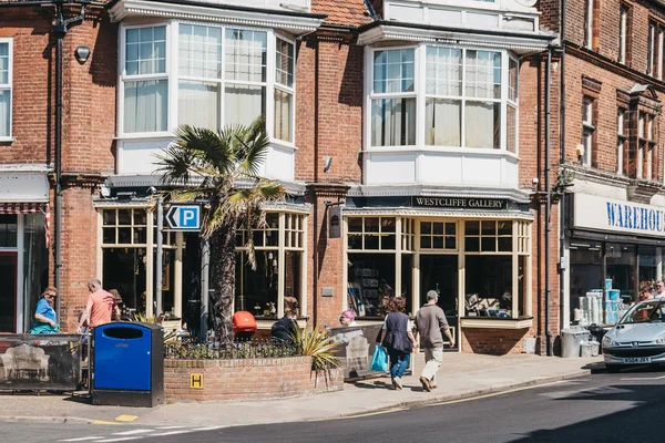 Persone a piedi passato negozi e caffè in una strada a Sheringham su — Foto Stock