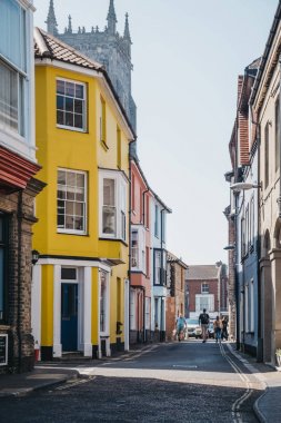 Cromer, Norfolk, İngiltere'de renkli evlerin önünden geçen insanlar.