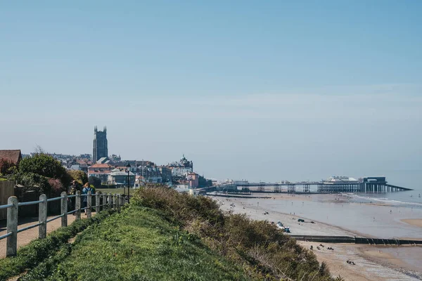 Ludzie spacerują po nadmorskiej ścieżce wzdłuż plaży w Cromer, — Zdjęcie stockowe