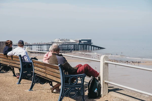 Senior couples enjoying sunny day on a bench by the sea in Crome — Stock Photo, Image