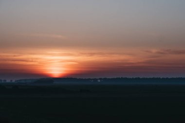 Tarlalar üzerinde gün batımından sonra kırmızı gökyüzü, İngiliz kırsal.