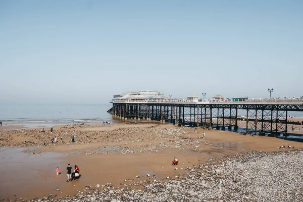 People on the beach in Cromer, pier on the background, Norfolk, — Stock Photo, Image