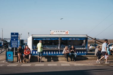 Wells-next-the-sea, Norfolk, İngiltere'de bir sokakta yürüyen insanlar.
