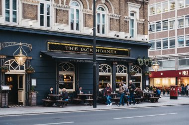 İnsanlar Tottenham Cour Jack Horner pub önünde yürüyüş