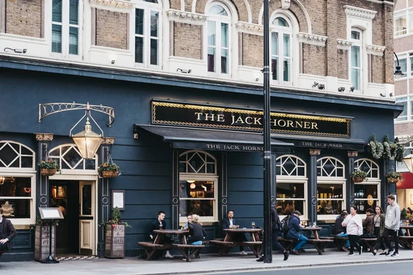 İnsanlar Tottenham Cour Jack Horner pub önünde yürüyüş