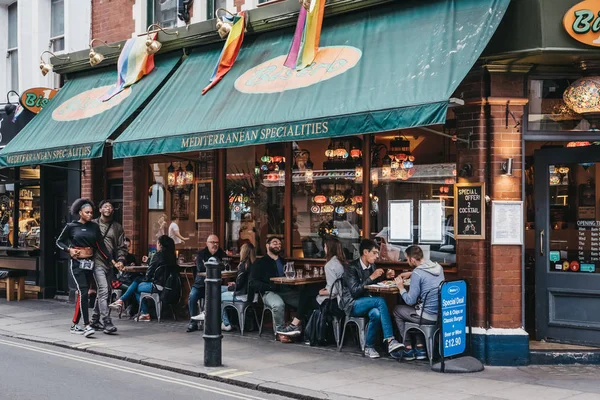 Lidé sedící u venkovních stolů ve středomořské restaurě — Stock fotografie