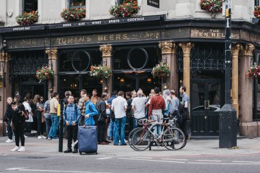 İnsanlar ayakta ve içecek dışında on Bells pub shored içinde