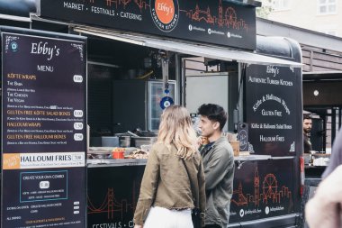 Spitalfields Market içinde Ebbys tezgahtan yiyecek sipariş insanlar