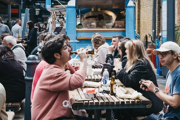 Ludzie cieszący się jedzeniem i napojami wewnątrz Spitalfields Market, Lond — Zdjęcie stockowe