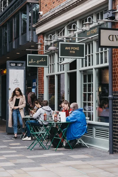 Menschen sitzen an den Tischen im Freien eines Cafés in Spitalfields m — Stockfoto