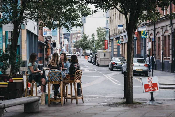 Des femmes assises aux tables extérieures d'un restaurant à Shoreditc — Photo