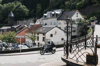 Vianden, Lüksemburg'da arnavut kaldırımlı bir sokakta motosikletçi.