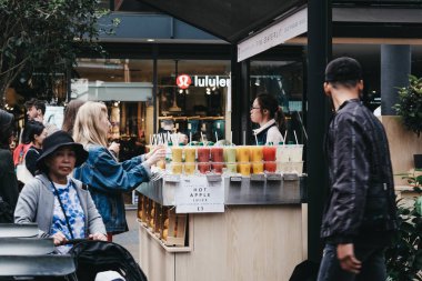 Spitalfields Market, Londra, İngiltere'den taze meyve suyu satın alan kişiler.