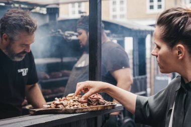 Spitalfi içinde bir Smokoloco tezgahında Izgara et örnekleme Kadın