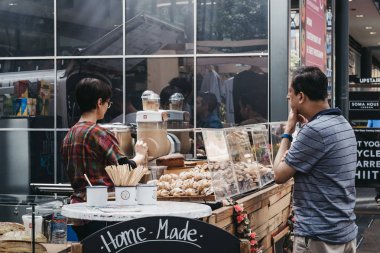 Spitalfields Ma içinde bir standda kahve ve tatlı sipariş Adam