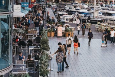 St. Katharine Docks'taki restoran ve kafelerin önünden geçen insanlar