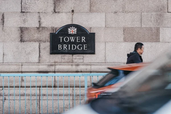 Autók vezetési és ember gyaloglás múlt a névtábla a Tower Bridge, — Stock Fotó