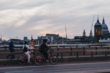 Genç kadın bisikletçi ile Londra Köprüsü üzerinde du geçen konuşan