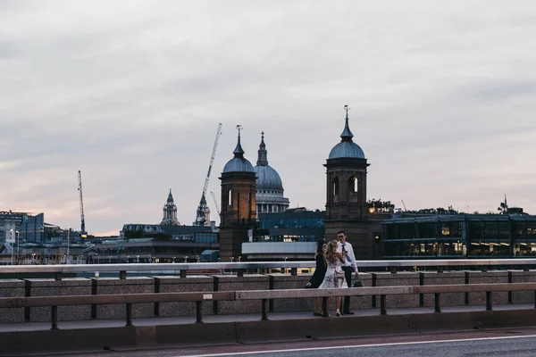 Menschen in Abendgarderobe stehen und reden auf der Londoner Brücke — Stockfoto