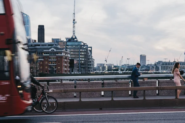 Emberek, kerékpárosok és a busz a London Bridge, uk, alkonyat, mozgás b — Stock Fotó