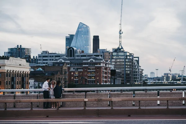 Akşam insanlar ayakta giymek ve Londra Köprüsü 'nde konuşurken — Stok fotoğraf