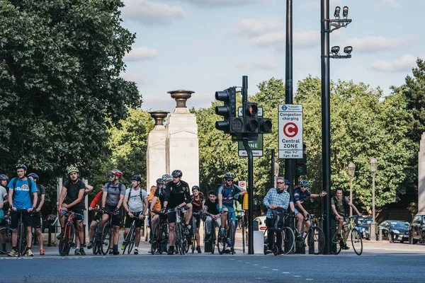 Ciclistas esperando en un semáforo rojo para cruzar una carretera en Londo — Foto de Stock