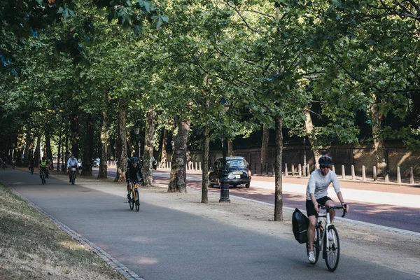 People cycling on a cycle highway in London, UK, in summer, moti