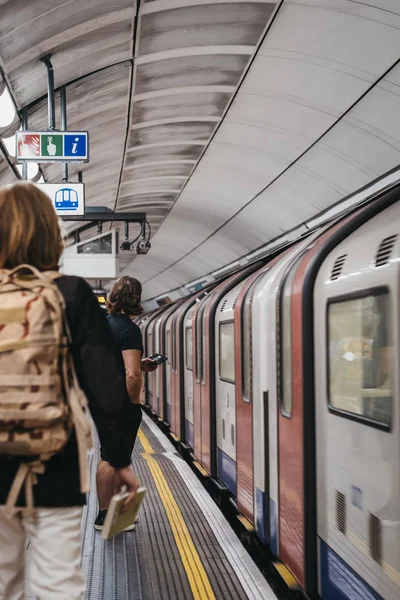 People on a London Underground station platform, train passing b — Stock Photo, Image