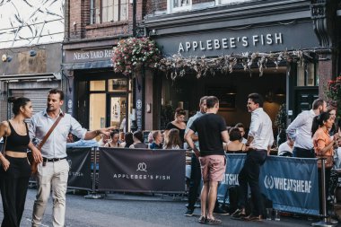 Bor 'da applebees balık restoranının açık masalarında insanlar