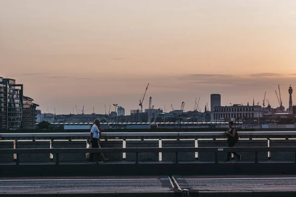 People walking on London Bridge, London, UK, at dusk, city on th — Stock Photo, Image