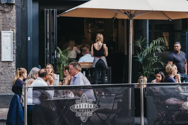 People sitting at the outdoor tables of Arthur Hoopers restauran — Stock Photo, Image