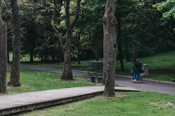 Man fietsen in een park in Luxemburg stad onder het groen. — Stockfoto