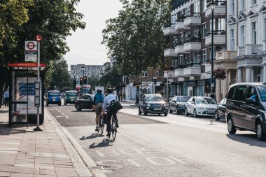 İnsanlar Pimlico bir sokakta bisiklet, Londra, İngiltere, altın sırasında