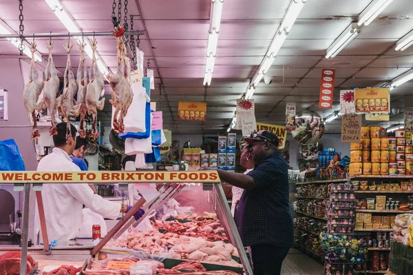 Säljare och kund pratar inne Brixton Foods Store på Brixto — Stockfoto