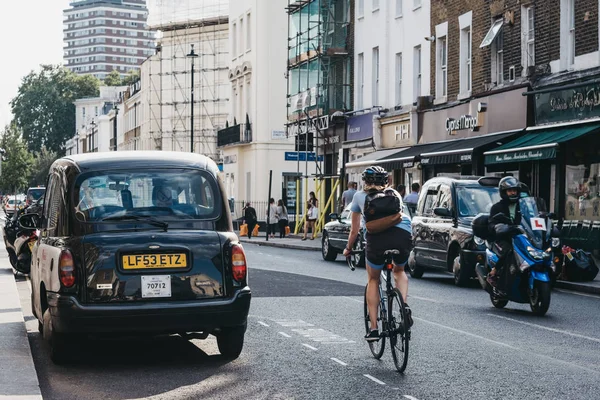 Mujer ciclismo en una calle en Pimlico, Londres, Reino Unido, enfoque selectivo — Foto de Stock