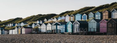 Milford on Sea, Ne'de gün batımı sırasında plaj kulübelerinin panoramik manzarası