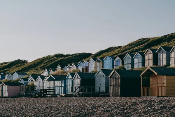 Cabanas de praia coloridas durante o pôr do sol junto ao mar, férias e viagens — Fotografia de Stock