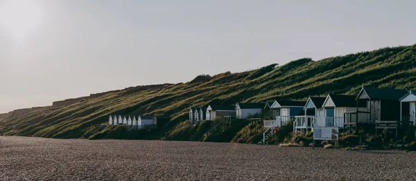 Cabanas de praia durante o pôr do sol em Milford on Sea, Hampshire, Reino Unido . — Fotografia de Stock