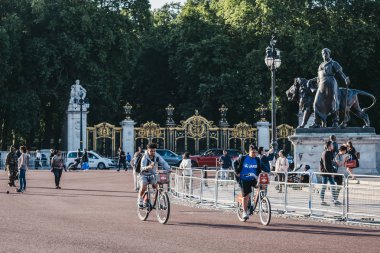 Buckingham Sarayı dışında bisiklete binen insanlar, Londra, İngiltere.