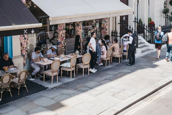Люди, сидящие за открытым столом кафе в Найтсбридже , — стоковое фото