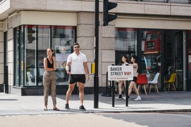 Baker Street, Londra, İngiltere'de sokak adı tabelası, yürüyen insanlar.