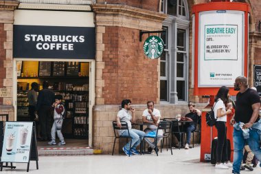 Marylebone İstasyonu, Lon içinde Starbucks masalarında insanlar