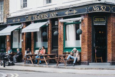 İnsanlar M Traders Inn pub açık masalarda oturan