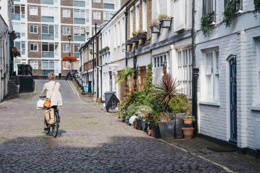 Paddington, Londo'daki mews evlerini bisiklete binen kadının arka görünümü