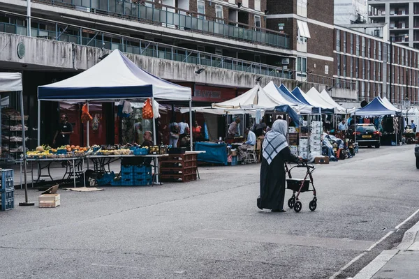 Frau läuft an Ständen auf dem Church Street Market vorbei, London, Großbritannien. — Stockfoto