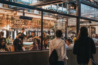 Co Buns ve Buns restoranın pencereleri önünden yürüyen kadınlar