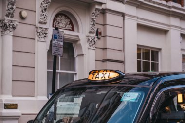 Londra'da siyah bir taksi de ışıklı bir taksi işareti yakın