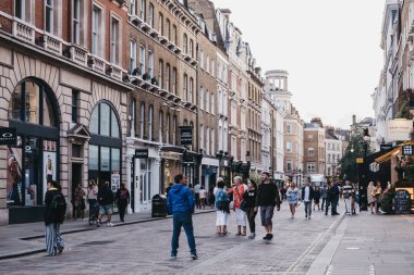 Covent Garden, Londra'da bir sokakta dükkanların önünden geçen insanlar, 